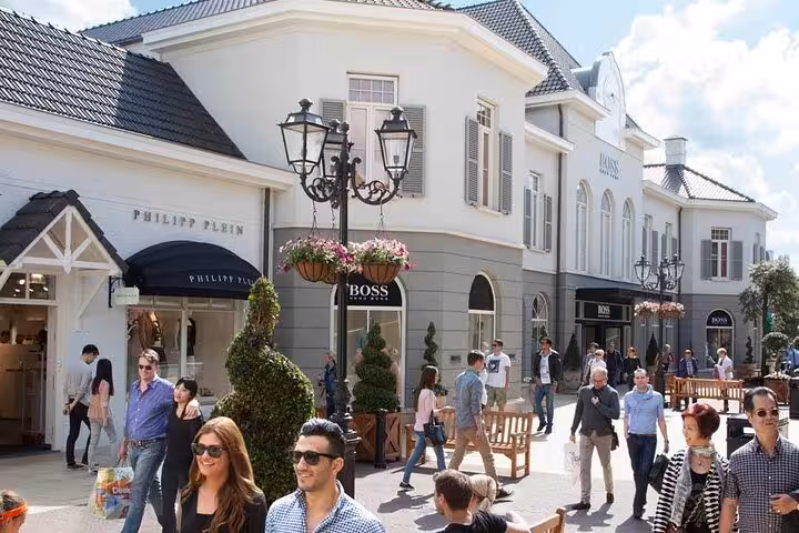 Shoppers strolling past luxury boutiques at Designer Outlet Roermond on a private day trip from Amsterdam
