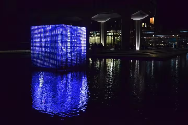 Blue light cube reflecting on canal at night in Amsterdam, perfect for Schiphol Airport to Eindhoven private transfer