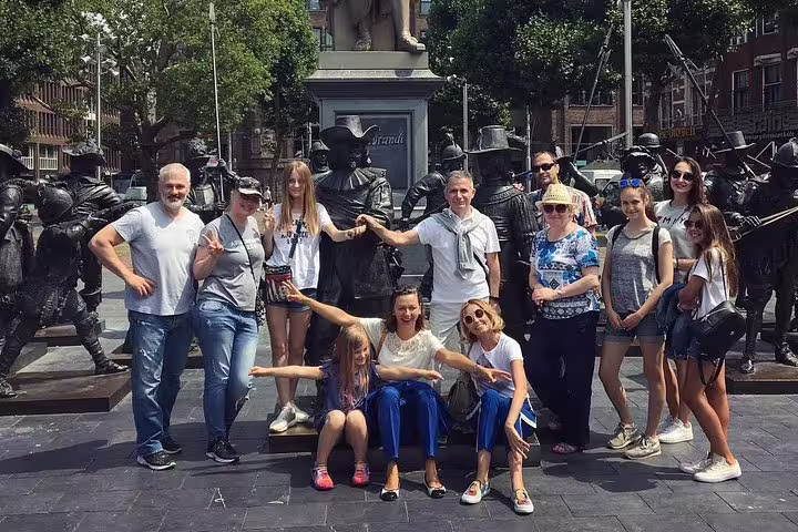 Amsterdam sightseeing tour group photo at Rembrandtplein statues, exploring hidden gems with tastings and guide