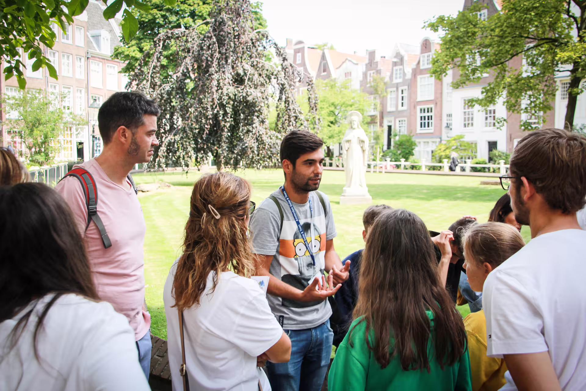 Tour guide leads a group exploring Amsterdam's historic sites on a walking, biking, and cruising tour with Dutch pancakes.