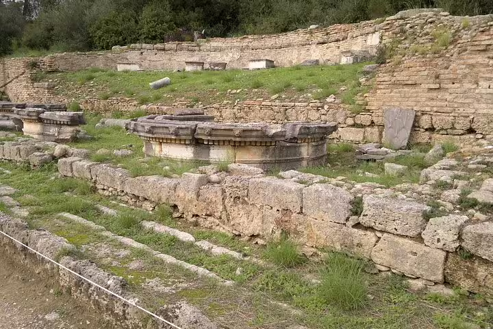 Ancient Olympia ruins with stone foundations and temple remains on a Greece day tour with meal included