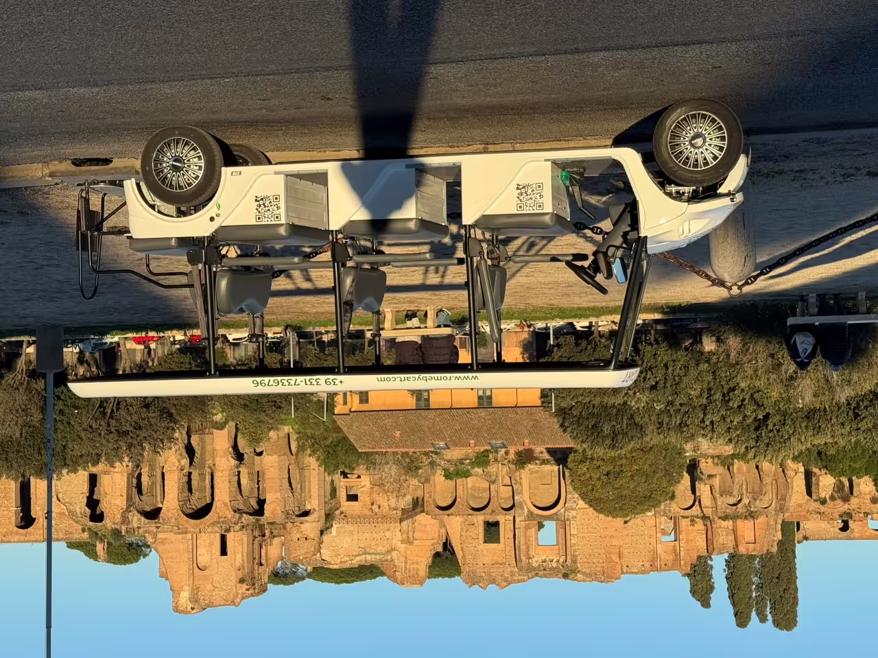 Ancient Rome golf cart sunset tour at 8pm with cart beside the Baths of Caracalla in golden light