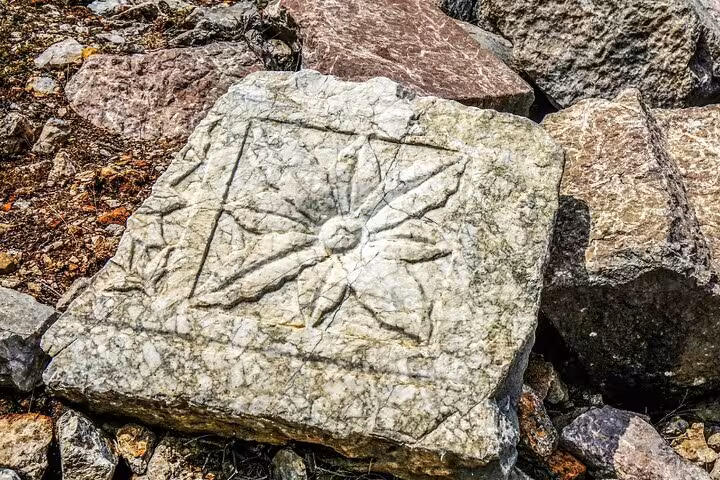 Ancient stone carving with floral motif in Turkey's historic village, showcasing rich archaeological heritage.