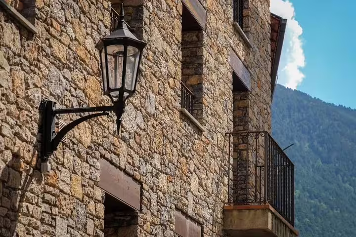 Charming stone building facade with vintage lantern in Andorra, highlighting traditional architecture on sightseeing tours.