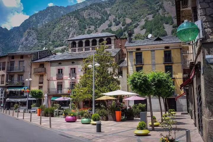 Charming Andorra town square with colorful seating and mountain backdrop, perfect for sightseeing and dining.