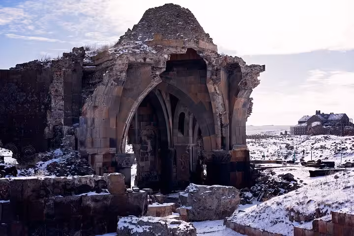 Ruined stone church arch in Ani Ancient City under snow, a must-see stop on the private guided 2-day Kars-Ani tour