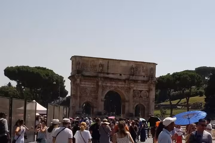 Visitors gather at the Arch of Constantine, an iconic Roman monument, during the Colosseum and Ancient Rome Express Tour.