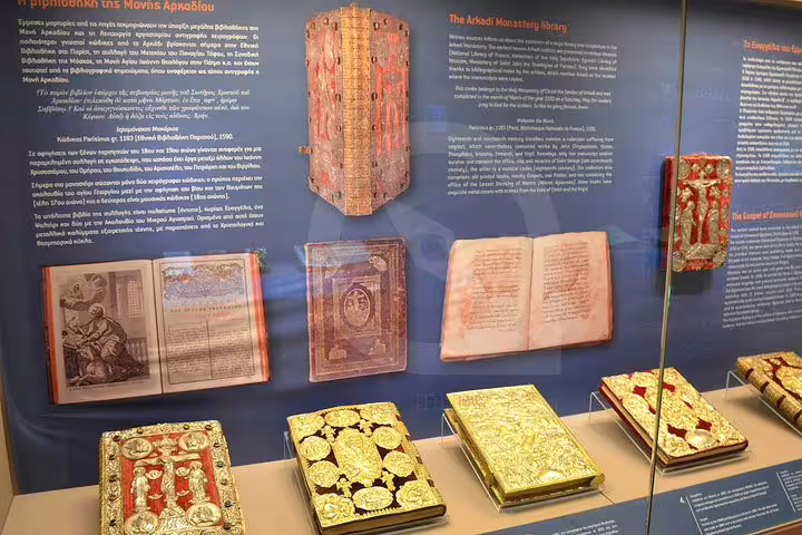 Discover ornate manuscripts and gold-embossed books in the Arkadi Monastery library exhibit.