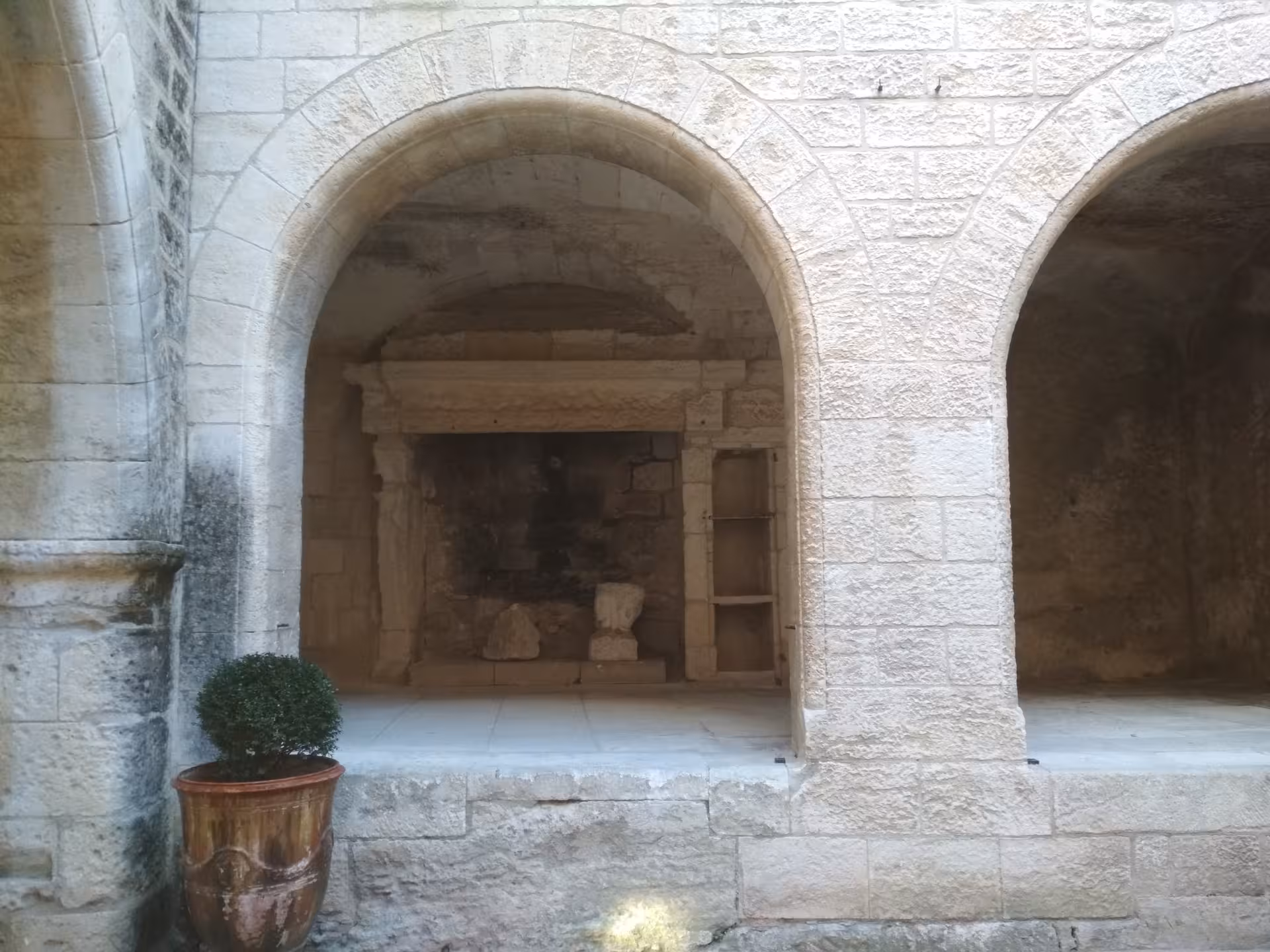 Romanesque stone arches and courtyard niche in Arles, Provence, featured on Arles and Les Baux de Provence tour