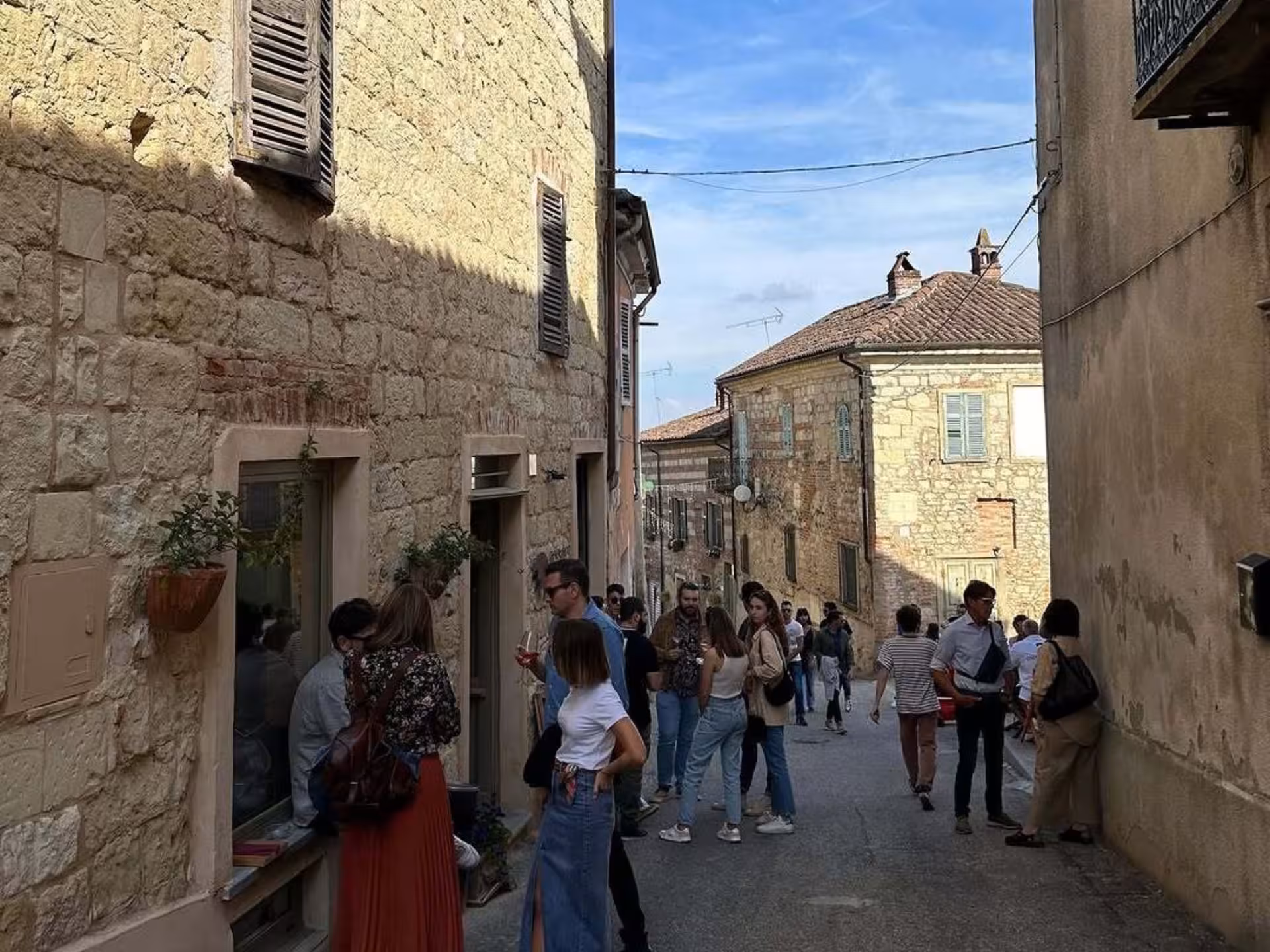 Visitors strolling through a quaint street in Asti, enjoying the local ambiance and traditional Italian architecture.