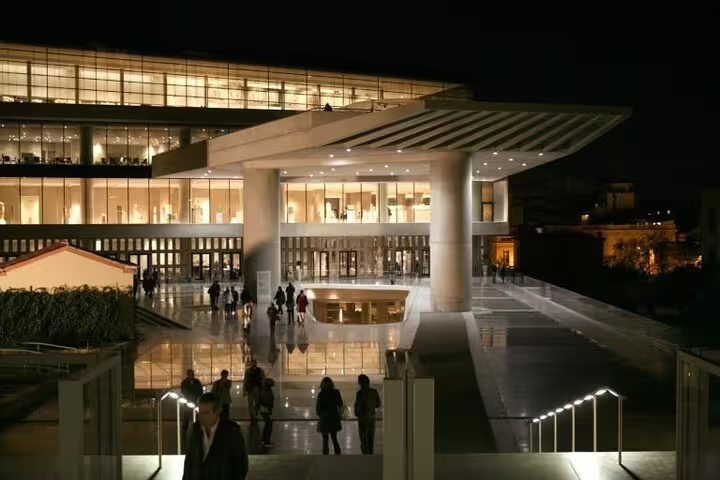 Athens Acropolis Museum entrance at night, visitors arriving for Friday guided tour with optional dinner