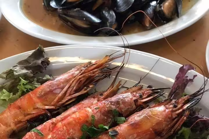 Greek seafood dinner in Athens featuring grilled prawns and mussels, part of Athens By Afternoon tour