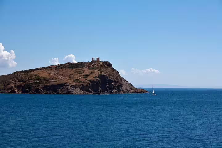 Aegean Sea view from Cape Sounion with sailboat and headland, Athens private day tour including meal