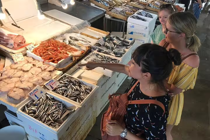 Travelers choose fresh seafood at Athens Central Market on a small group walking food tour with tastings