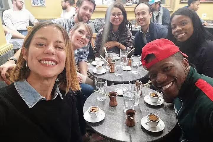 Small group enjoying Greek coffee tasting at a traditional Athens café on a gourmet food walking tour