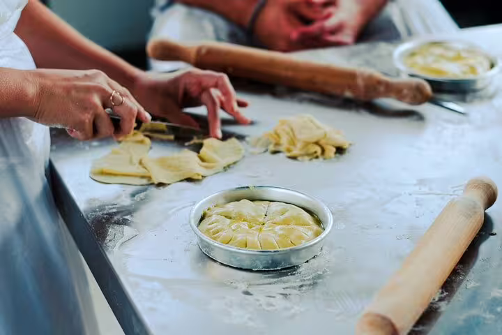 Athens Greek cooking class making traditional pie with rolled pastry and olive oil, before rooftop dinner with Acropolis view