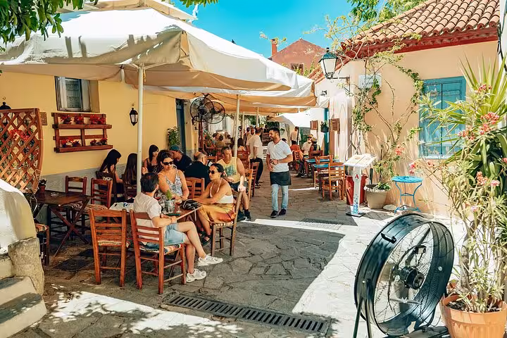 Sunny Plaka alley café seating in Athens, traditional neighborhood visit on small-group panoramic tour