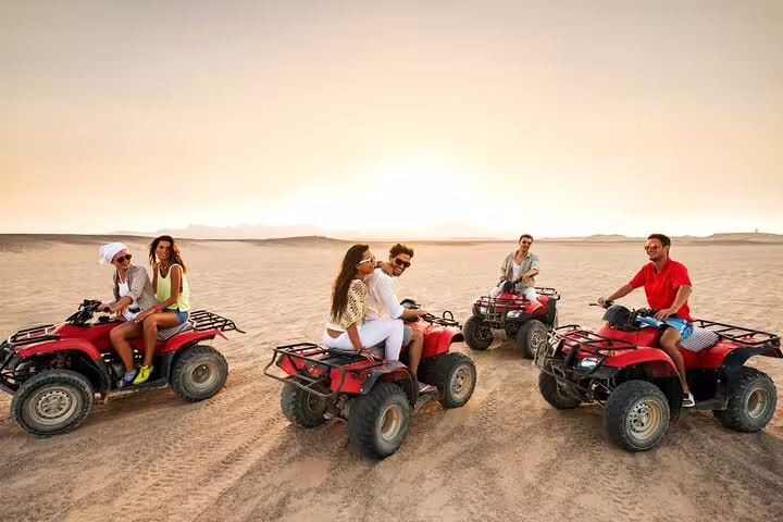 Group of friends enjoying an exciting ATV ride across the desert landscape at sunset, ideal for adventure enthusiasts.