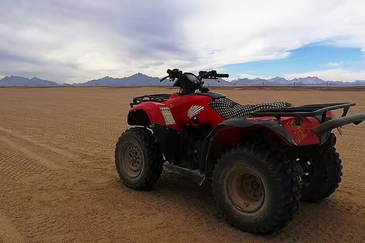 ATV quad bike parked on wide Marsa Alam desert plain, ideal for quad safari before camel ride and Bedouin dinner
