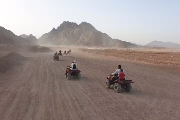 ATV convoy rides across Sinai desert towards mountains on Double quad bike safari tour from Sharm El Sheikh