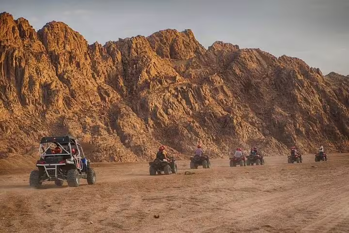 Marsa Alam quad bike safari convoy by rocky mountains at sunset, part of ATV tour with Bedouin dinner show