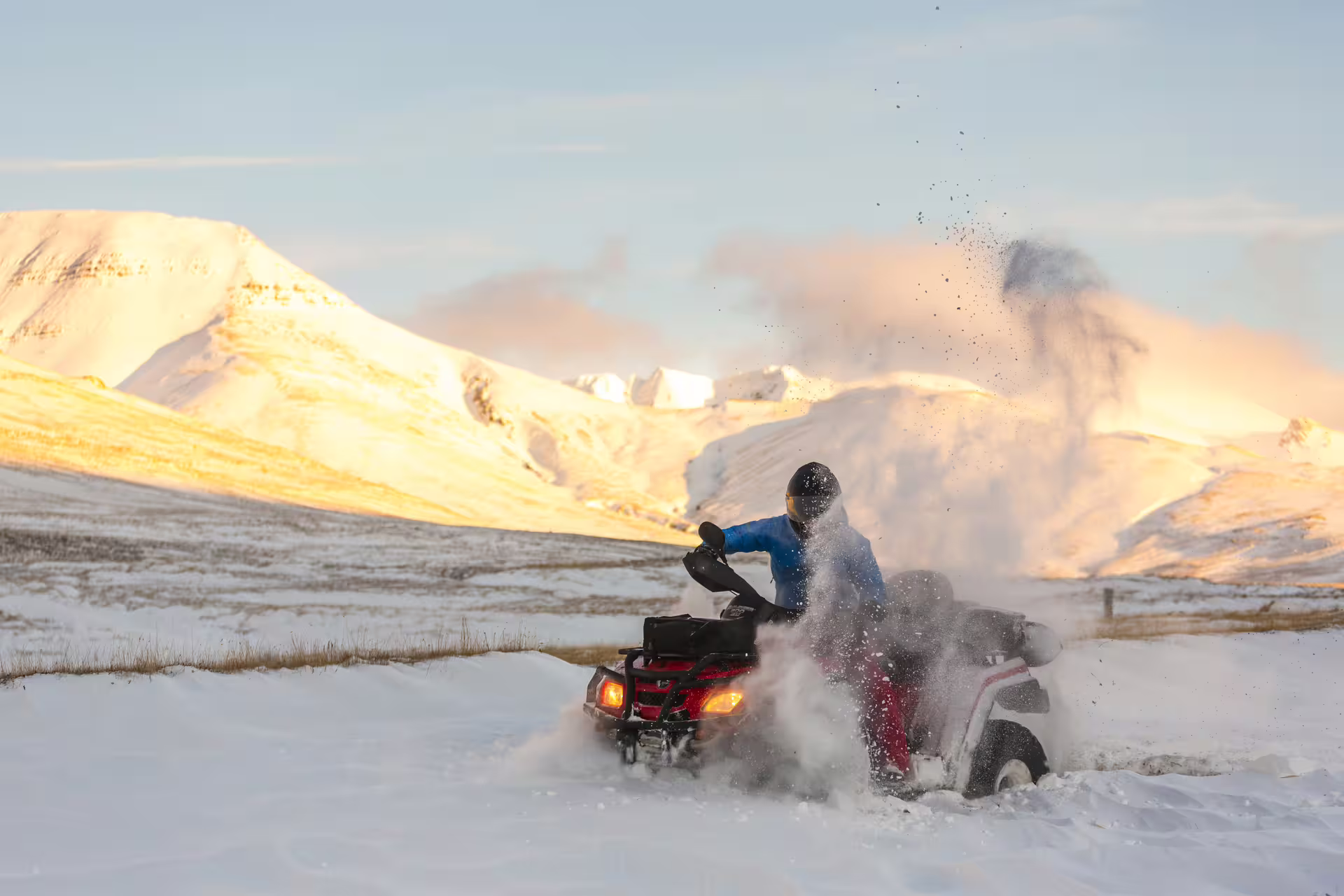ATV rider navigates snowy volcanic landscape with scenic mountain backdrop during an adventurous 3-hour Volcanic Springs tour.