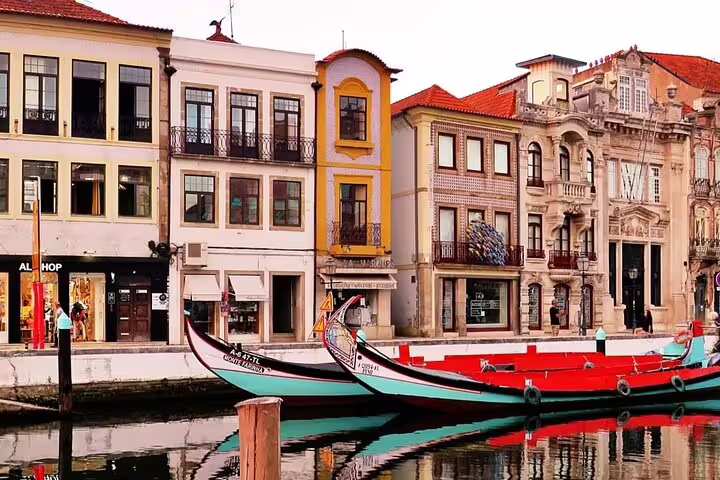 Colorful moliceiro boats in the canal with charming, historic buildings in Aveiro on a private full-day tour from Porto.