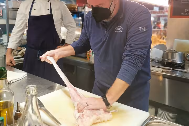 Avignon cooking class with exceptional chef demonstrating fish filleting technique in a professional kitchen