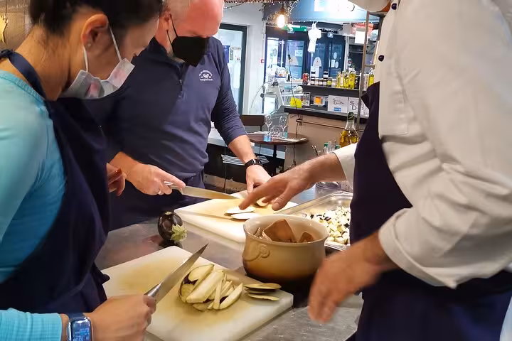 Guests chopping vegetables with the chef in an Avignon cooking class, hands-on French cuisine workshop