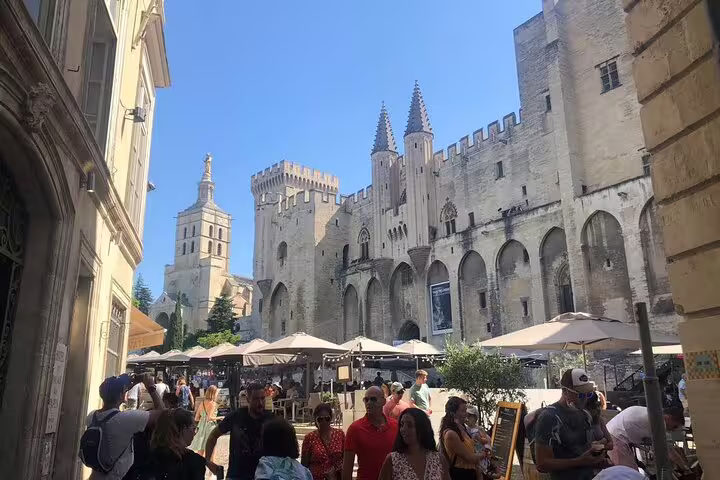 Crowded square by Palais des Papes in Avignon, ideal stop on a self-guided e-scavenger hunt city tour