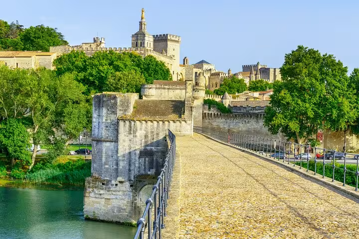 Scenic view of the famous Pont Saint-Bénézet leading to Avignon's historic Palais des Papes, a highlight of the walking tour.