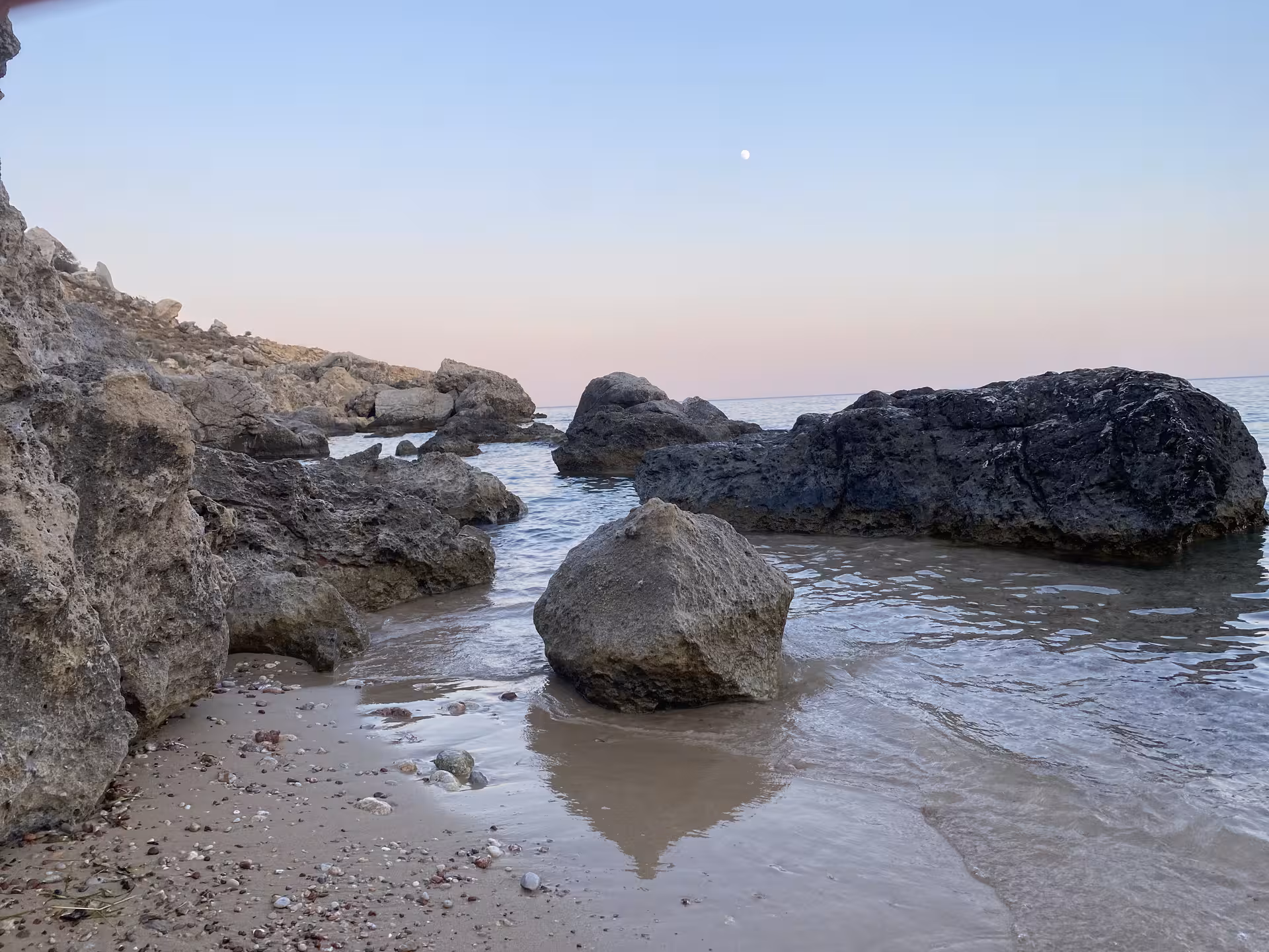 Rocky shoreline and calm sea at Blue Lagoon stop on Axopar 25 CT boat tour, perfect for swimming