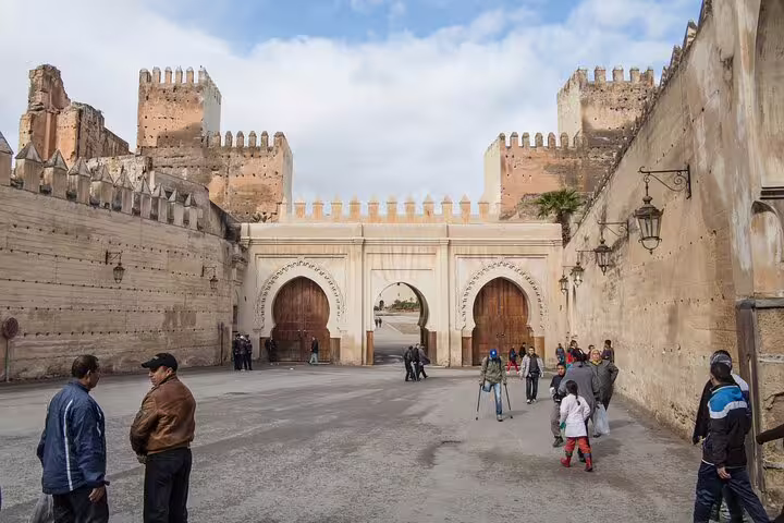 Bab Bou Jeloud blue gate entrance in Fes Medina, Morocco, on a guided walking tour with local visitors