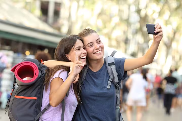 Two backpackers taking a selfie while playing a Pisa e-scavenger hunt, a self-guided city exploration game