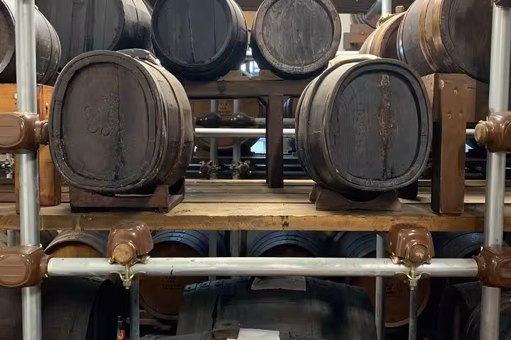 Wooden barrels aging traditional balsamic vinegar in a rustic cellar, highlighting the Taste Tour experience.