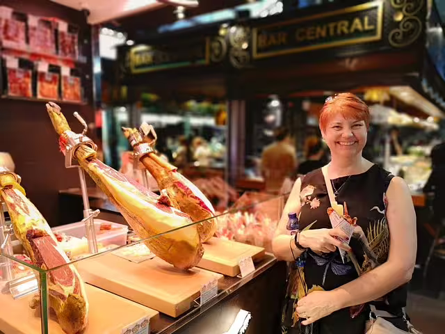Smiling visitor enjoying traditional Spanish jamón at a bustling Barcelona market during a private food and drink tour.