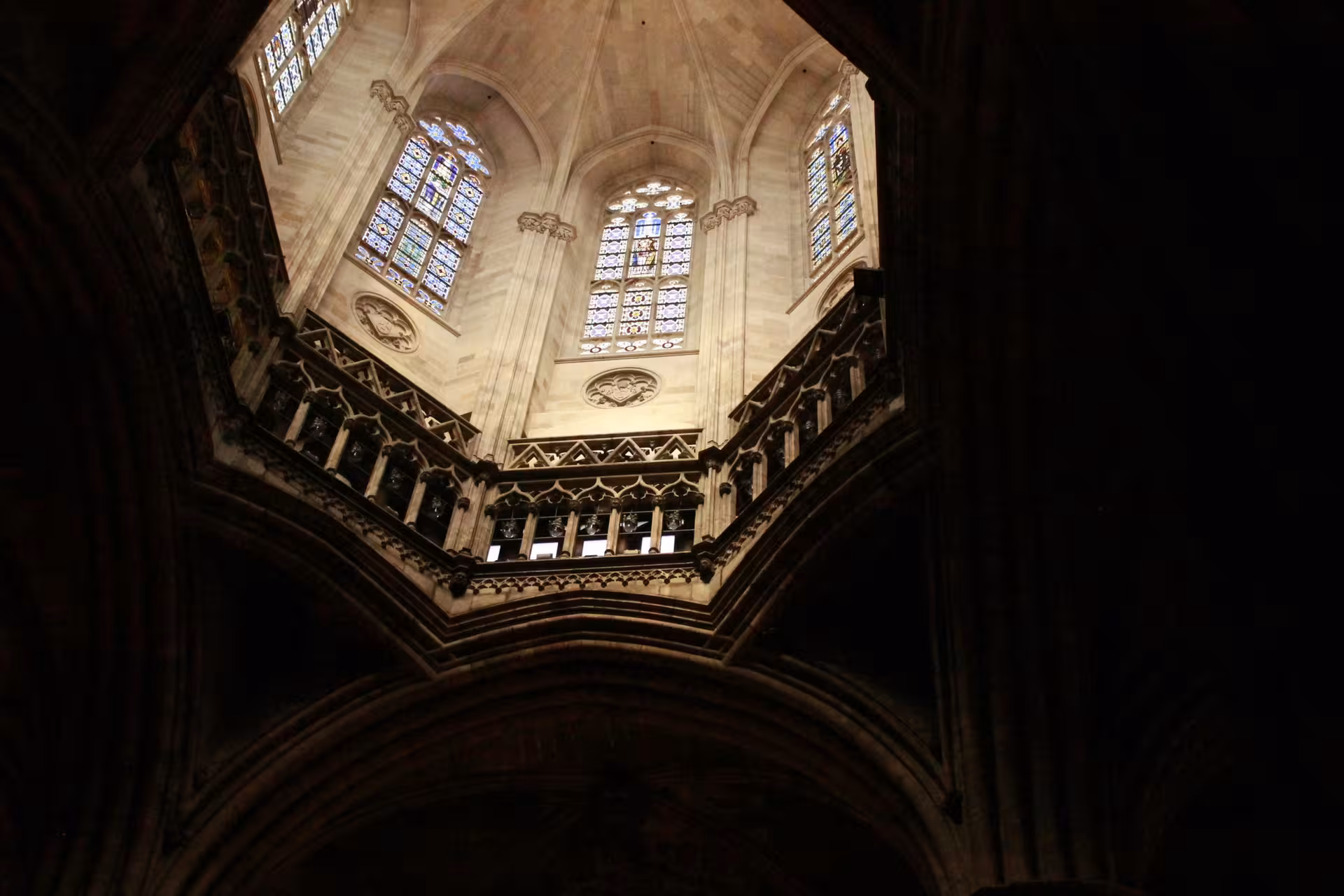 Majestic Gothic architecture with stained glass windows inside Barcelona's Gothic Quarter cathedral.
