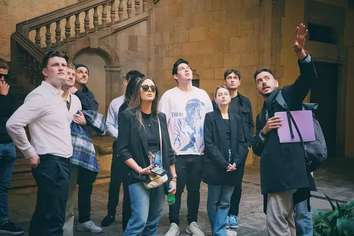 A guided group explores the historic charm of Barcelona's Gothic Quarter, listening to detailed explanations of its architecture.