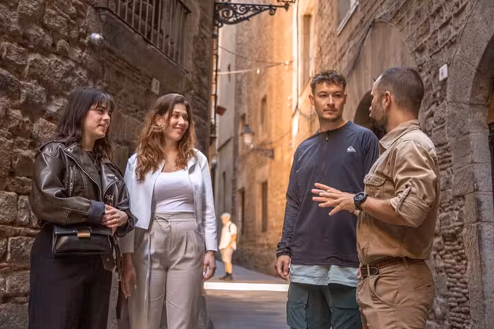 Small group walking tour in Barcelona Gothic Quarter alley, guide explaining Old Town highlights near El Born