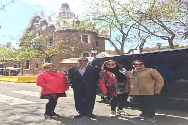 Tourists posing in front of a historic building in Park Güell, capturing a memorable Barcelona city tour moment.