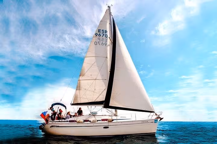 Private sailboat in Barcelona with guests relaxing on deck, open bar and snacks, Mediterranean sea views