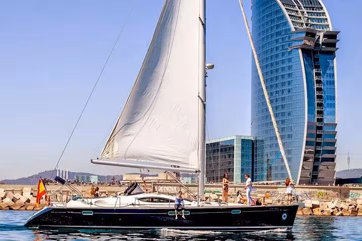 Barcelona private sailing tour with open bar and snacks, yacht near Port Vell and W Barcelona hotel skyline
