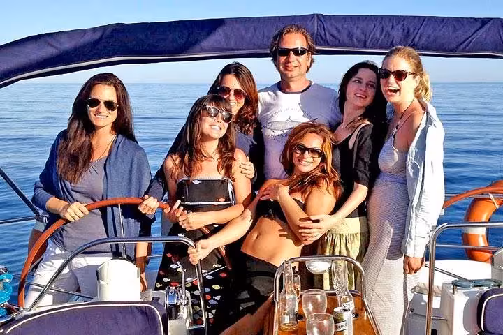 Group enjoying a Barcelona private sailing experience on a yacht, open bar drinks and snacks on deck