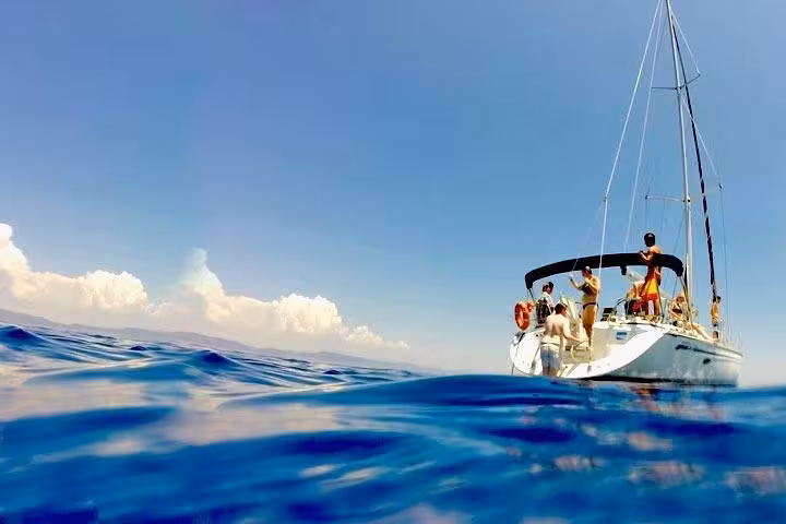 Small group Barcelona private yacht sailing with open bar and snacks, viewed from sea level on calm waters
