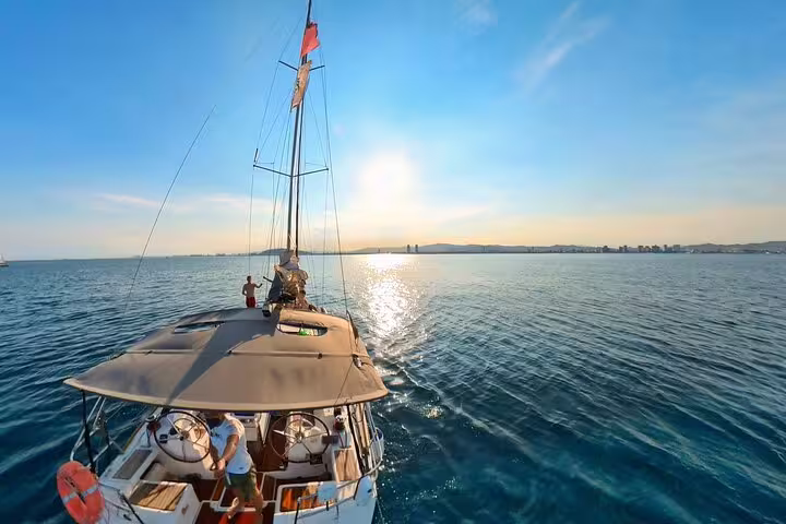 Sail the sparkling Mediterranean near Barcelona with a small group, enjoying snacks and cava under a beautiful sunset.