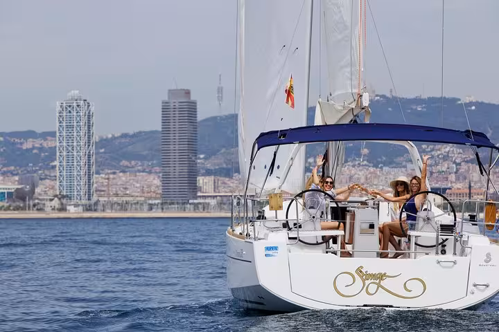 Group sailing past Barcelona skyline on a 2-hour sailboat tour with open bar drinks and snacks