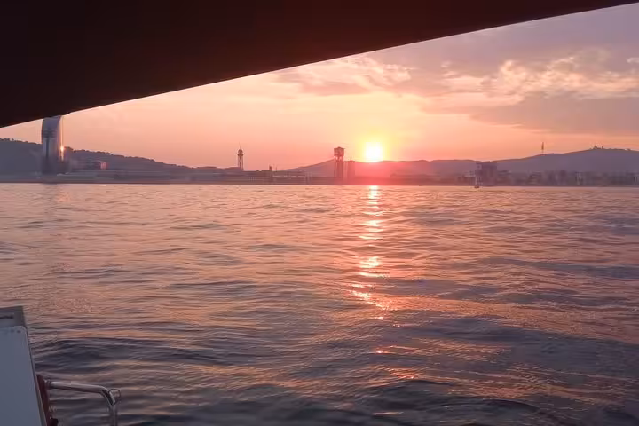 Barcelona sunset view from a sailboat on a 2-hour sailing tour with open bar and snacks on the Mediterranean