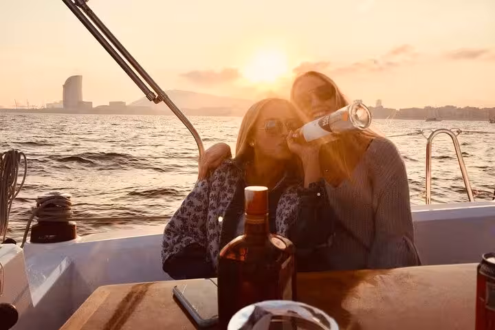 Guests toast on a Barcelona sunset sailing tour with open bar and snacks, cruising past the W Hotel