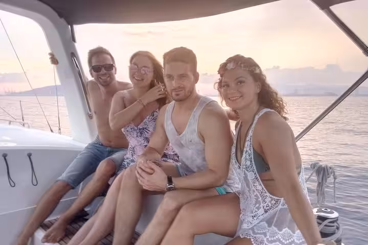 Group enjoying sunset sailing in Barcelona on a yacht with open bar and snacks, relaxing on deck seats