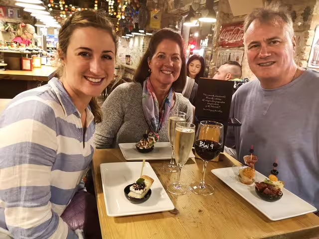 Group enjoying tapas and wine at traditional Barcelona tavern during a private culinary tour, showcasing vibrant local flavors.